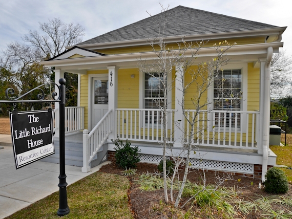 Exterior of the Little Richard House & Resource Center in Macon, Georgia, a small yellow historic home with a front porch and accessible ramp.